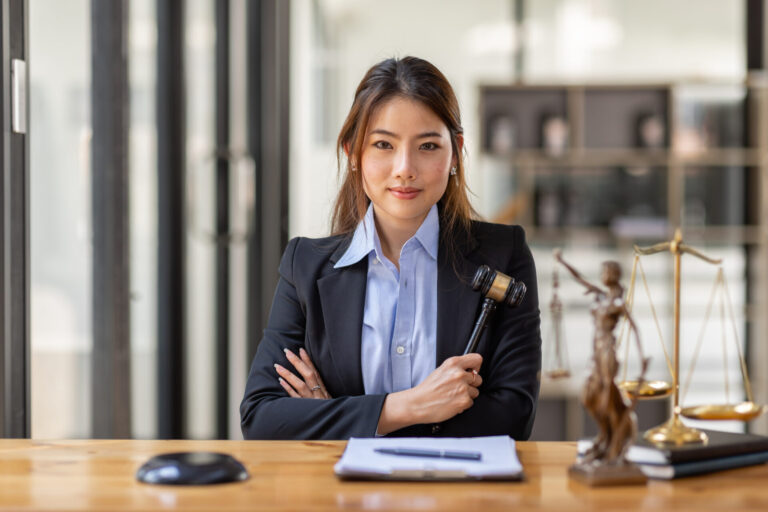 Female lawyer holding gavel in office.