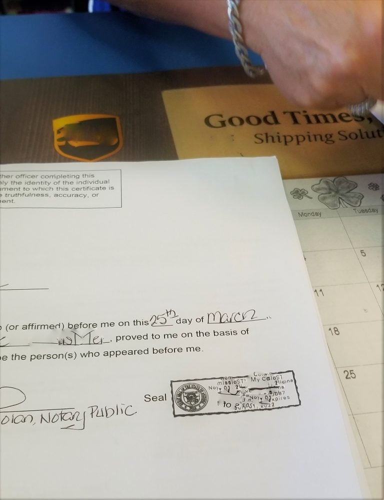 Notary signing document at Good Times office