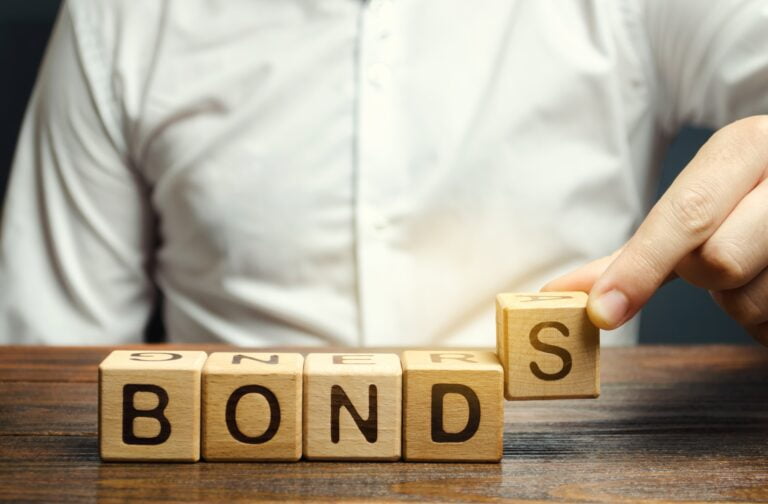 Hand arranging wooden blocks spelling BONDS