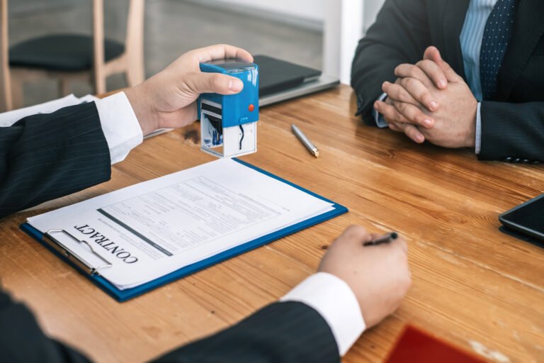 Business contract being stamped on wooden table.