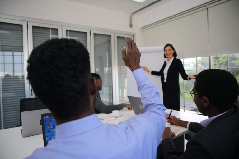 Business meeting with presentation and participant raising hand