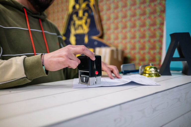 Person stamping papers on desk
