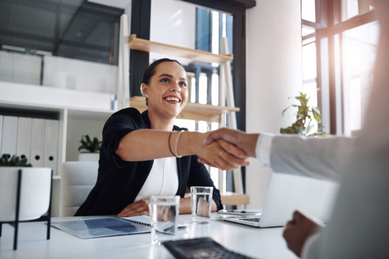 Woman in office shaking hands, smiling