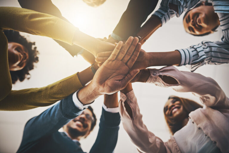Diverse group joining hands in unity.