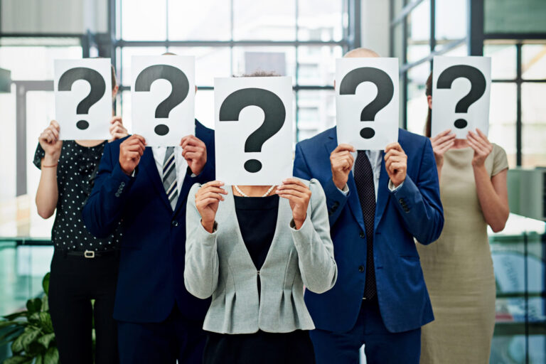 People holding question mark signs over faces